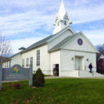 White church with steeple and Seventh-day Adventist church sign